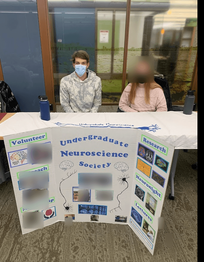 Original photograph of Jonah at the Undergraduate Neuroscience Society booth, with other faces blurred